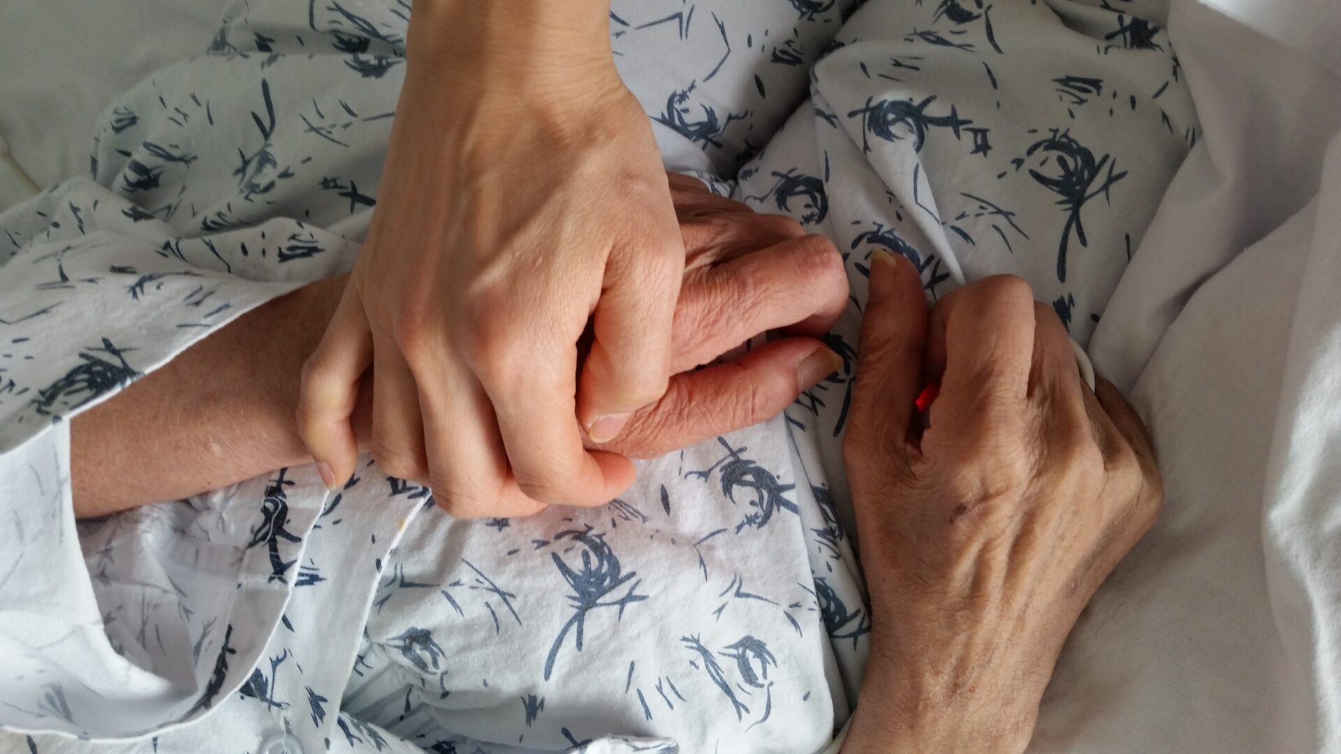 Supporting someone through end of life. Holding their hand for support.