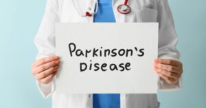 Doctor holds a sign saying 'Parkinson's Disease'